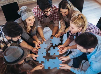 A group of employees collaboratively assembling a jigsaw puzzle, symbolizing teamwork and unity.