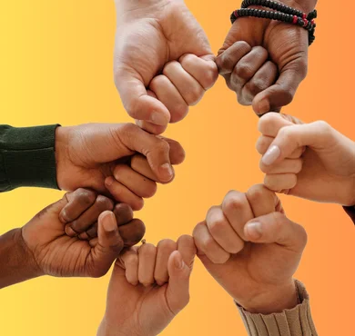 A circle of hands of different skin tones in a gesture of unity and solidarity.